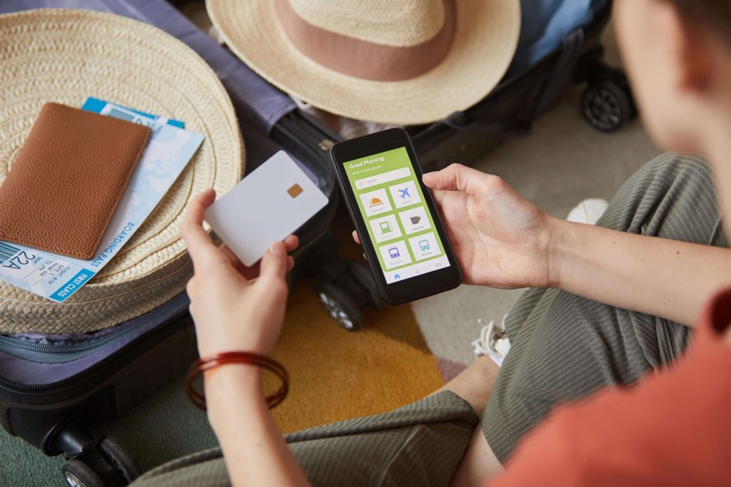 Mujer utiliza Apps para realizar su viaje y paga con tarjeta de crédito